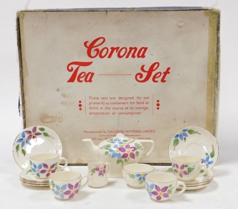 A Corona porcelain child's tea set, decorated with blue and purple flowers, against a white ground, boxed.