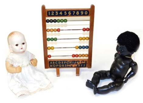 A vintage Chad Valley abacus, 39cm high, together with a Rosebud black composition doll, and a mid century celluloid doll. (3)