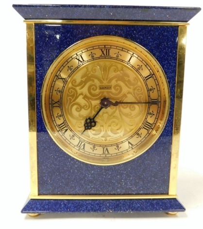 A Luxor simulated lapis lazuli and brass mantel clock, circular dial with chapter ring bearing Roman numerals, clockwork movement, the case of rectangular form, raised on brass feet, 18cm high, 14.5cm wide.