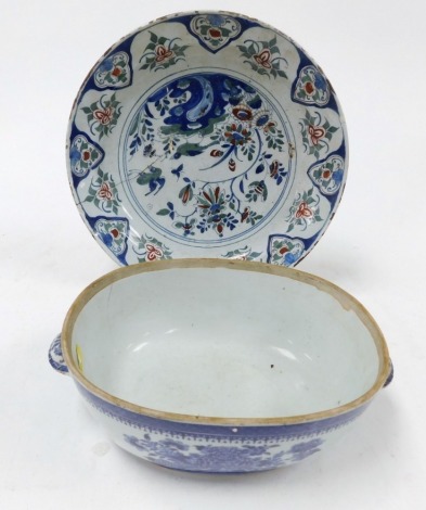 An 18thC English polychrome Delftware dish, painted centrally with birds and flowers, within a repeating floral borders, 32.5cm wide, together with a Qing dynasty blue and white porcelain tureen, painted with flowers and scrolls, 29cm wide. (AF, 2)