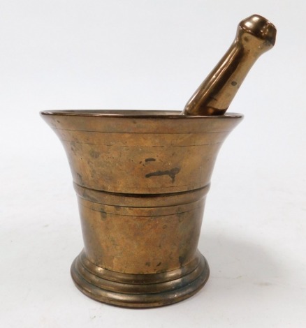 A bronze pestle and mortar.