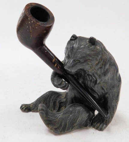 An early 20thC Black Forest cast metal pipe holder, modelled as a seated bear, with a briarwood pipe.