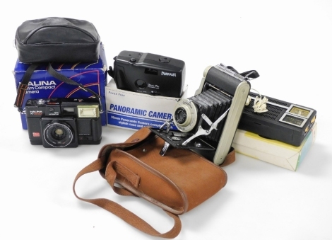 A Coronet Rapide folding camera, in case, together with a Halina 35mm compact camera, Elftone pocket radio, and a panoramic camera.