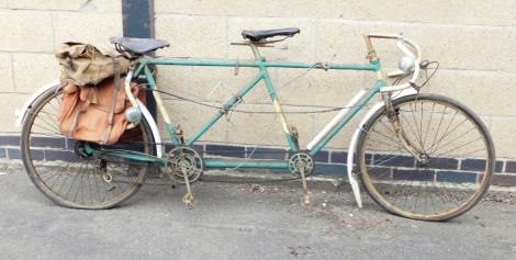 A vintage Reynolds tandem bicycle, in green trim, with leather seats and various canvas saddlebags. (AF)