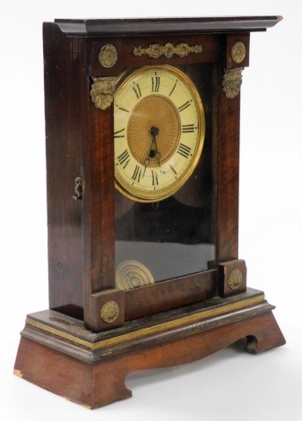 A late 19thC American mahogany cased mantel clock, circular brass dial with chapter ring bearing Roman numerals, thirty hour movement, the case lacking pediment, with brass appliques, raised on ogee bracket feet, with pendulum, no key, 46cm high, 28cm wid