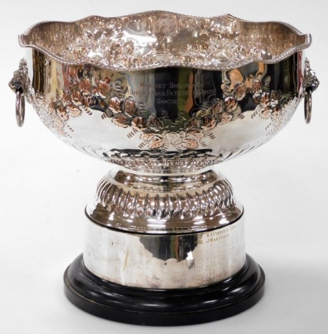 A silver plated presentation punch bowl, engraved for The Market Bosworth Christmas Fatstock Show Society, The Ralph Greenfield trophy, with twin lions head and ring handles, the body embossed with floral swags above semi fluting, raised on a socle base, 