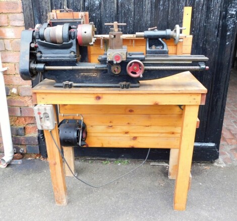 A Winfield lathe, mounted on an oak table top 132cm high, 90cm wide, 44cm deep. Buyer Note: WARNING! This lot contains untested or unsafe electrical items. It is supplied for scrap or reconditioning only. TRADE ONLY