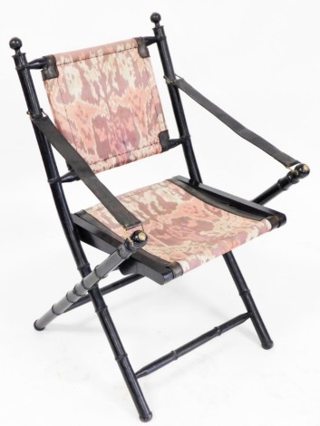 A Victorian style ebonised faux bamboo folding chair, with leather strap arms, fabric back and seat, 55cm wide.