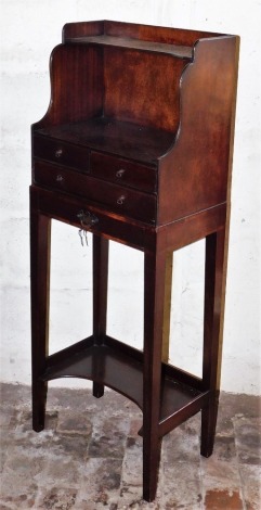 A late Georgian mahogany side cabinet, the galleried top with a shaped shelf above a recess, with an arrangement of two short and two long drawers, with small drop handles and a larger handle, on square tapering legs with under tier, 119cm high, 45cm wide