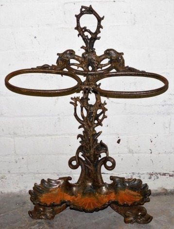 A Victorian Coalbrookdale style polished cast iron umbrella stand, in rococo style, with two divisions and a stylised branch handle, the base cast with shells, on dolphin feet, 82cm high.