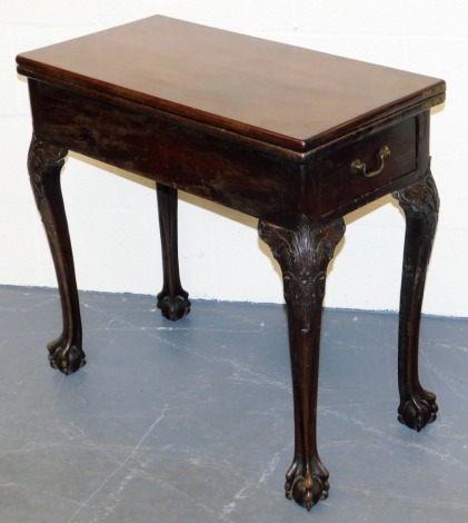 A George III mahogany fold over card table, the rectangular top enclosing a baize interior, on carved cabriole legs with ball and claw feet, 72cm high, 76cm wide, 38cm deep.