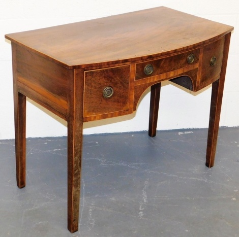 A George III mahogany bow fronted side table, the top with a boxwood strung cross banded border, above an arrangement of three drawers around an arched recess, on square tapering legs, 73cm high, 42cm wide, 52.5cm deep.