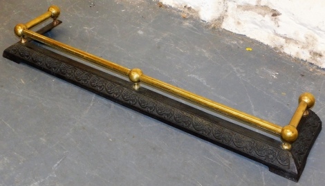 A Victorian cast iron and brass fender, with plain cylindrical rail, the base decorated with flowers and leaves, 117cm wide.