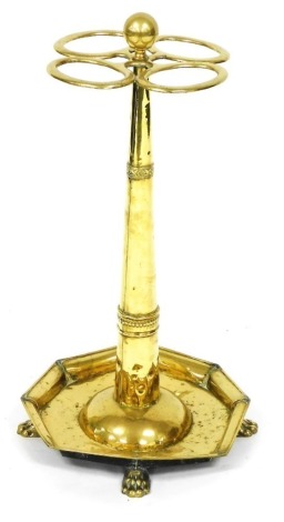 A 19thC Continental brass umbrella stand, with turned finial, four oval recesses, and a tapering column, the drip pan with raised sides, on paw feet, 66cm high.