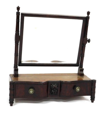 A Regency mahogany dressing table mirror, the rectangular bevelled plate on turned supports, the shaped base with a single drawer carved with a patera, on simulated bamboo supports, 62cm high, 57cm wide.