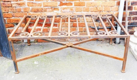 An unusual cast iron coffee table, with scroll carved top, plain supports and X shaped stretcher, possibly constructed from a railing or balcony rail, 52cm high, 36cm wide, 75cm deep.