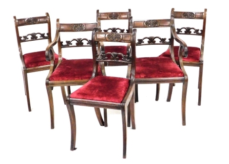 A set of six Regency mahogany dining chairs, each with a leaf carved bar back, drop in seat, on sabre legs, two with arms.