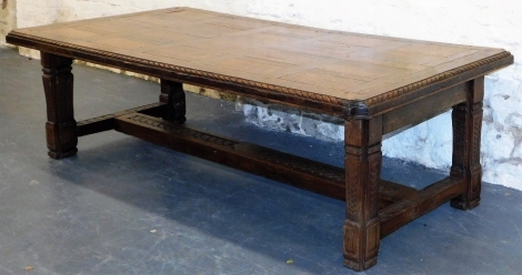 A late 19th/early 20thC oak refectory table, the top with a rope twist border, and re-entrant corners, on carved square tapering legs with H stretcher, glass top, 71cm high, 135cm wide, 125cm deep.