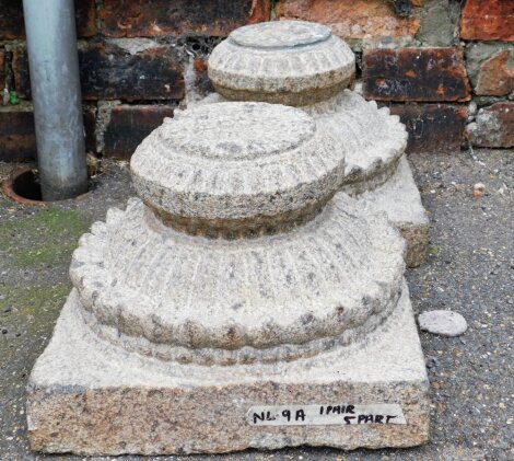 A pair of carved stone garden urn bases, each with carved decoration, on a square foot, 32cm wide.