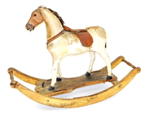 A 19thC rocking horse, the leather horse with leather saddle, pine head, the base with two handles, etc., 127cm wide. (AF)