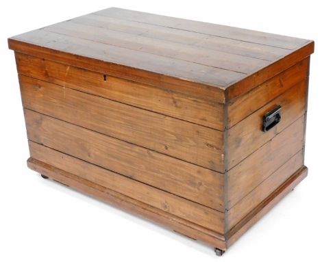 A stained pine blanket chest, raised on a plinth base, on castors, 61cm high, 97.5cm wide, 57.5cm deep.