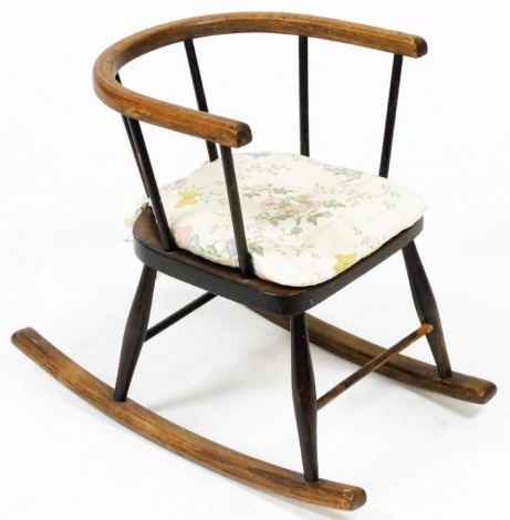 An early 20thC oak and elm child's rocking chair, 37cm wide.