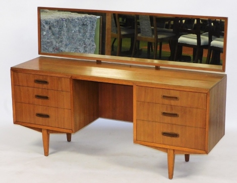 A mid century teak dressing table, bears label for DBS, the adjustable rectangular mirror over six drawers, raised on tapering square legs, 105.5cm high, 149cm wide, 41cm deep.