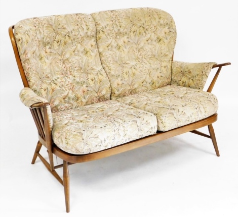 An Ercol two seater elm sofa, with floral upholstered button back cushions and seats, 138cm wide.