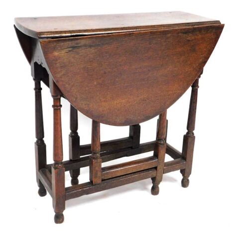 An 18thC oak drop leaf occasional table, with a single frieze drawer, raised on turned legs united by a box frame stretcher, 71cm high, 70cm wide, 31cm deep, 95cm extended.