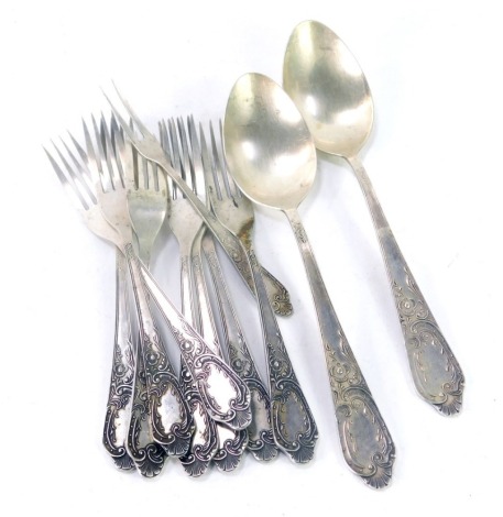 A group of Soviet era silver flatware, with embossed floral and foliate scroll decoration, vacant shield terminal, comprising eight dessert forks, pair of serving spoons, and a pickle fork, bears 875 silver marks, 15.92oz