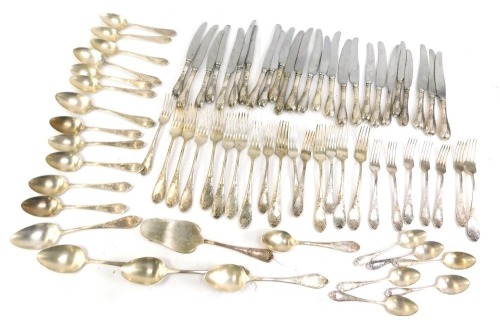 A group of Soviet era flatware, white metal, with embossed foliate and rococo scroll handles, including table forks and knives, table and dessert spoons, tea spoons, cake slice, and dessert forks (a quantity)