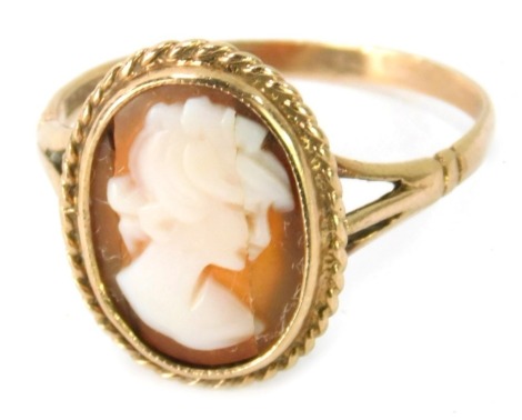 A 9ct gold cameo dress ring, the oval cameo depicting maiden looking right, with rope twist border, on V splayed shoulders, ring size Q½, 2.6g all in.