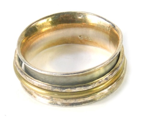 A dress ring, of curved outer design with hammered three band interior, white metal stamped 925, ring size R½, 7.8g all in.