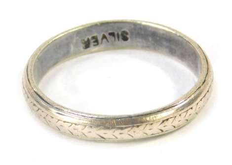 A silver wedding band, of hammered floral design, size N 1/2, 2.5g all in.