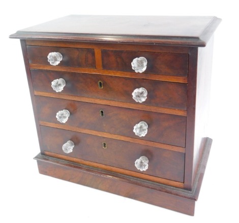 A Victorian mahogany apprentice chest, of two short over three long drawers, with applied glass handles, raised on a plinth base, 32cm high, 34cm wide, 20cm deep.