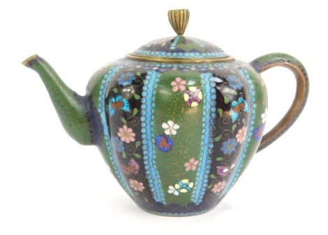 A late 19thC Chinese cloisonne enamel teapot, of lobed form, decorated with flowers and butterflies on a blue, black, green, and turquoise ground, 16cm wide.