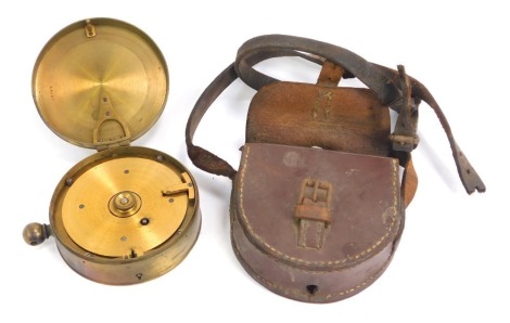 A circular brass clockwork military instrument, modelled as a pocket watch, number to inside 28744, within a fitted leather pouch, 11.5cm diameter.