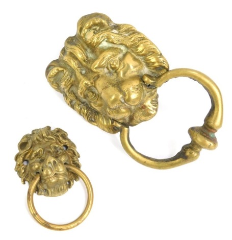 A brass lion's mask door knocker, 13.5cm wide, together with a smaller example, 7cm wide. (2)