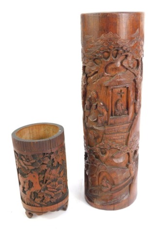 Two Chinese carved bamboo brush pots, comprising one with carved figures in windows, 37cm high, and another on tripod base with birds, 17cm high. (2)