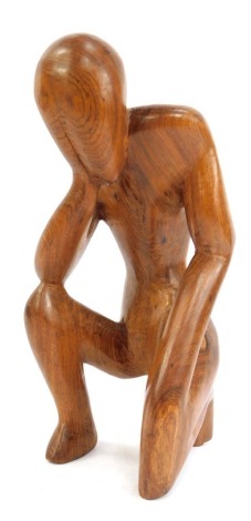 A carved wooden figure, of a person in seated pose, 35cm high.