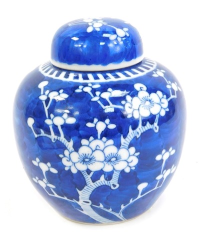 An early 20thC Chinese porcelain blue and white ginger jar and cover, decorated with prunus blossom against a cracked ice ground, 15cm high.