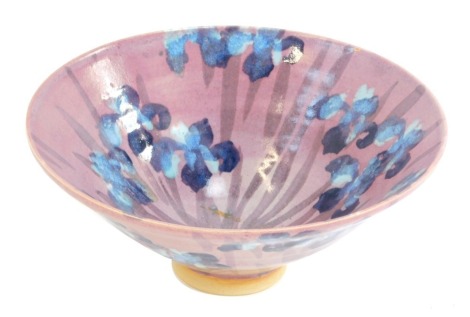 A studio pottery floral bowl, decorated with irises against a pink ground, unmarked, 26cm diameter.