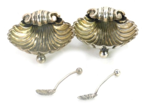 A cased pair of Victorian silver salts, of scallop shell form, comprising two salts and two spoons, William Henry Leather, Birmingham 1892, 2.44oz.