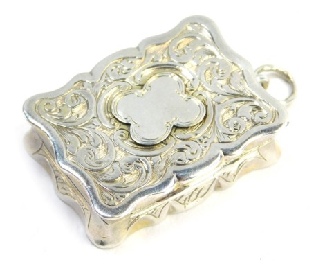 A Victorian silver vinaigrette, of serpentine form, with engraved foliate decoration, central vacant shield reserve, on a ring suspension, Hilliard and Thompson, Birmingham 1858, 17.6g.