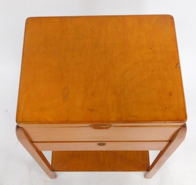 A mid century pine sewing table, the hinged lid opening to reveal a green silk lined interior, over a drop flap, enclosing two frieze drawers, all containing sewing accoutrements, raised on square legs united by an under tier, 66cm high, 39cm wide, 30cm d - 2