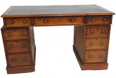 A Victorian mahogany twin pedestal desk, with a black leatherette top, over one long and eight short graduated drawers, raised on plinth bases, 79cm high, 136cm wide, 77cm deep.