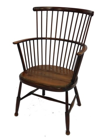 A 19thC oak comb back Windsor chair, with later pine seat, raised on turned legs, united by a H frame stretcher, 56cm wide.