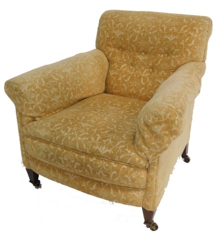 A late Victorian mahogany armchair, with button back gold and white foliate fabric, raised on lined inlaid tapering square legs, brass capped on castors, 77cm wide.