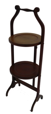 An Edwardian mahogany two tier folding cake stand, 75cm high.