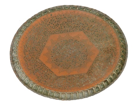 A Middle Eastern copper tray, embossed and engraved with hunting figures, within similar borders, together with script, 76cm wide.